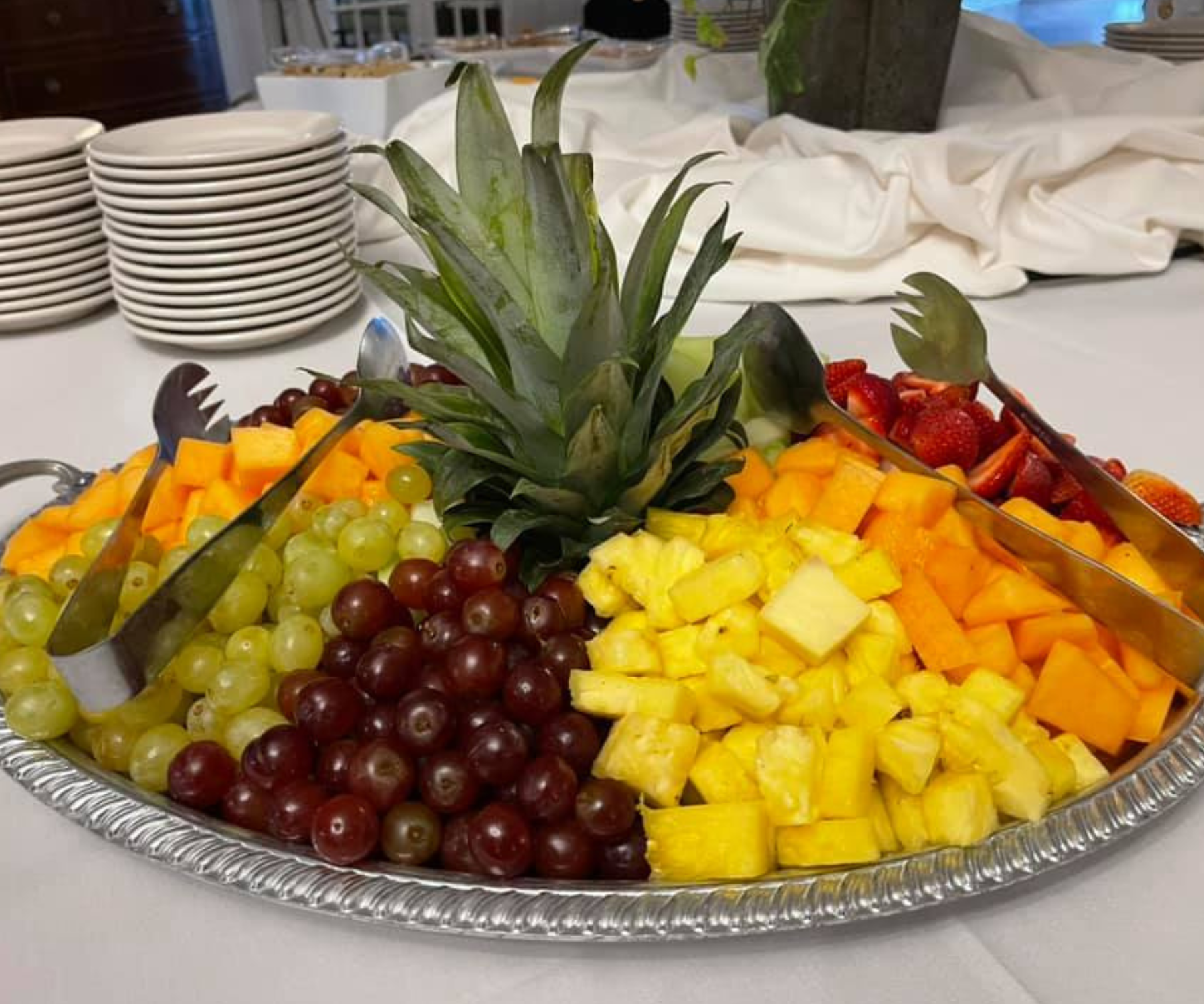 Fruit platter with grapes, pineapple, mangoes, and strawberries at Darlington Country Club's dining area